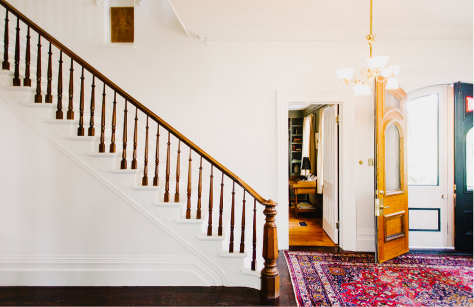 Grand wooden staircase and entryway with an ornate front door