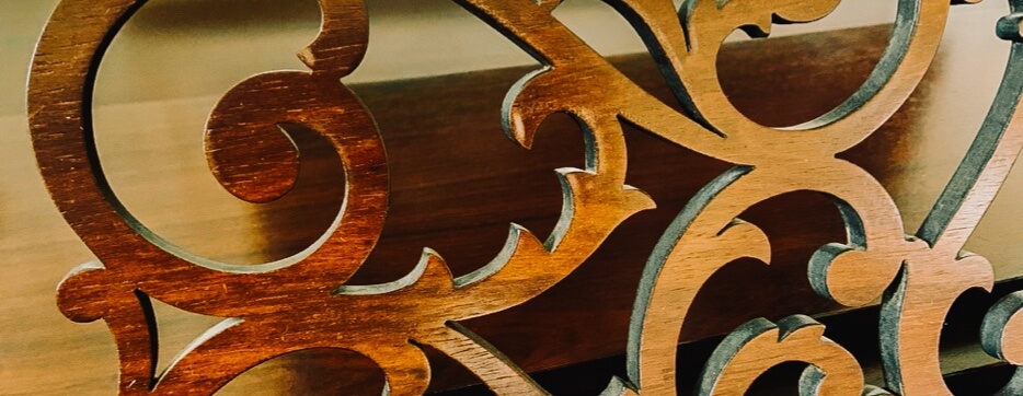 Close-up of carved wood scrollwork detail on furniture