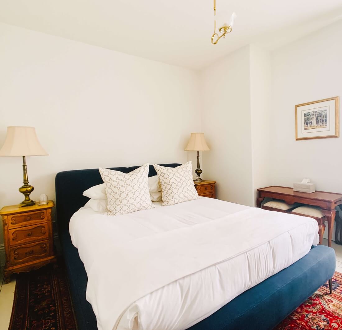 Bedroom with a navy upholstered headboard and matching bench